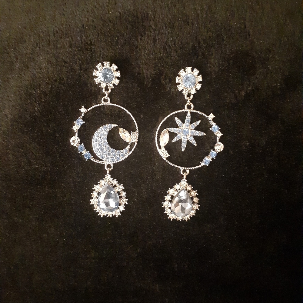 The Silver Lunar's blue crystal moon, star, and water dangle hoop earrings